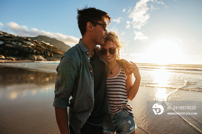 Romantic young couple standing together on beach