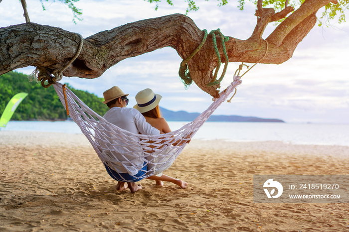 couple lover enjoy honeymoon and long vacation on the sea beach, siiting on the swing together relax