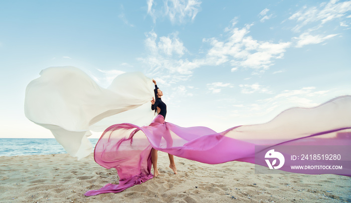 Slim Woman at the beach with long pink fabric. Sky background at the summer. Classic dancer on the n