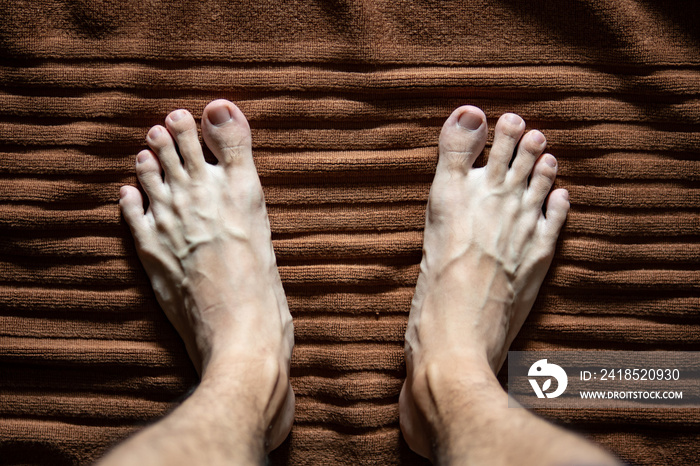 Men legs on bath mat