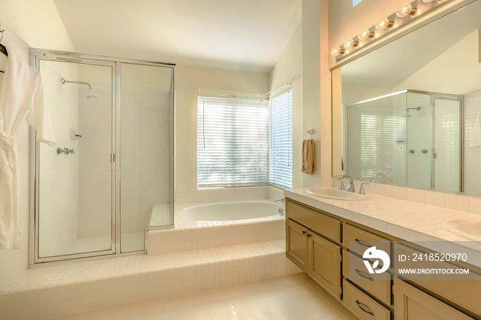 Bathtub and double vanity unit inside the well lighted bathroom of a home