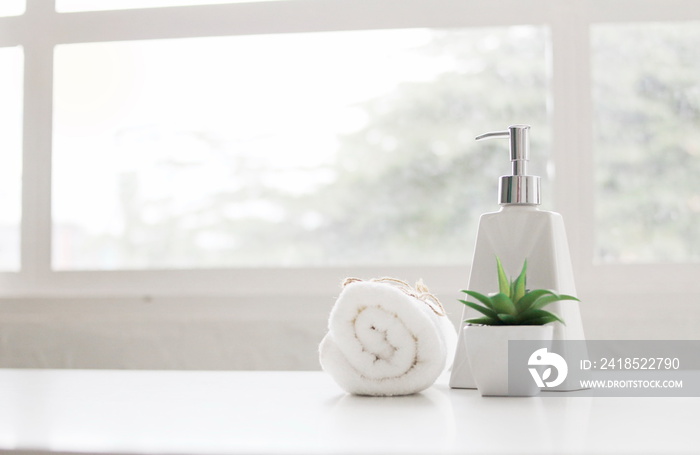 Soap dispenser and spa towel ,Roll up of white towels on white table with copy space,towels studio s