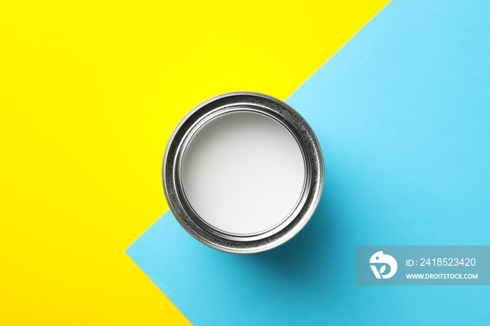 Can of white paint on two tone background, top view