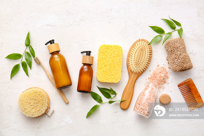 Set of bath supplies with sponges and plant branches on white background