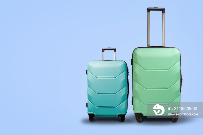 Two Suitcases on wheels on a blue background. Сoncept of travel, a vacation trip, a visit to relativ