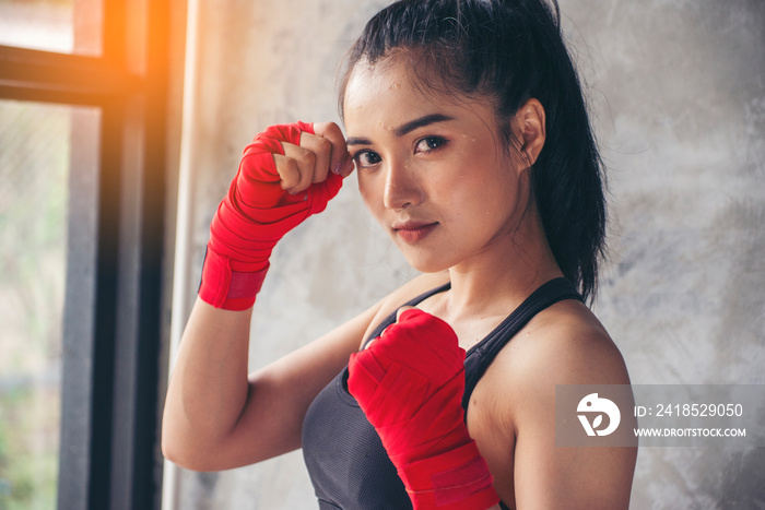 Fit Female strap on her wrist and exercise hard to strengthen muscle.Boxing Woman prepare to trianin