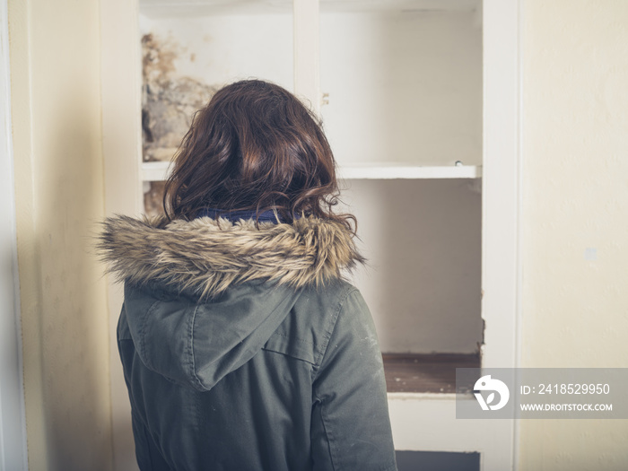 Woman in coat looking at old cupboard