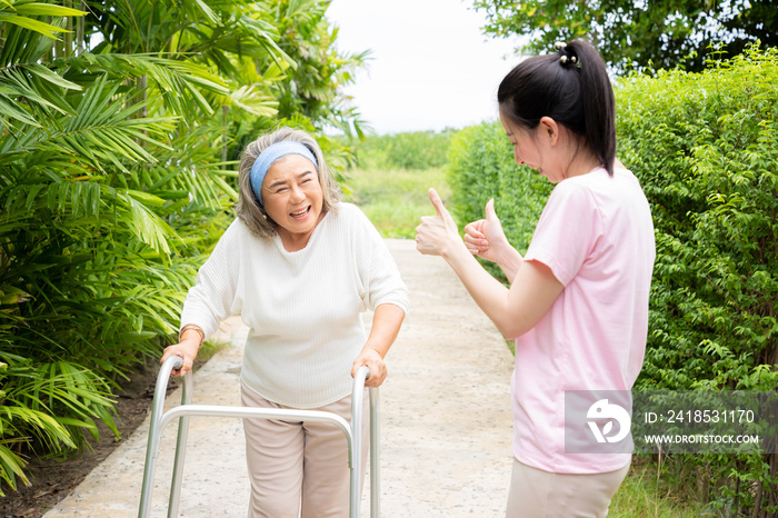 一位老年妇女因患有心脏病，试图在花园里用助行器耐心锻炼