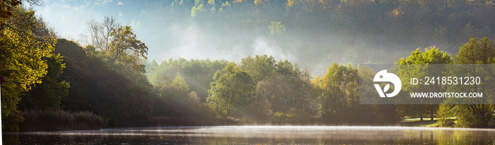 Panorama of foggy lake with Autumn foliage and tree reflections in Styria, Thal, Austria