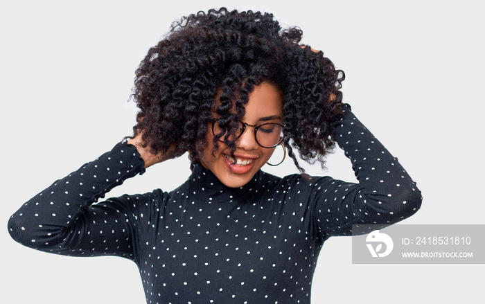 Happy dark-skinned young woman dressed in black long sleeve shirt with white dots and spectacles, ho