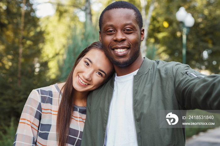 Young beautiful couple making selfie at park