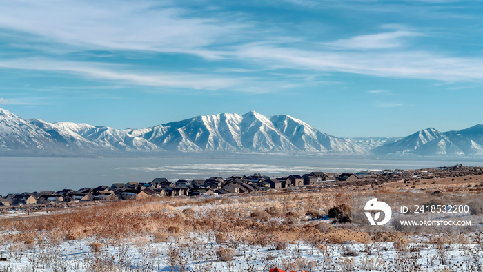 Panorama Rugged Wasatch Mountains and icy Utah Lake with snowy terrain in the foreground