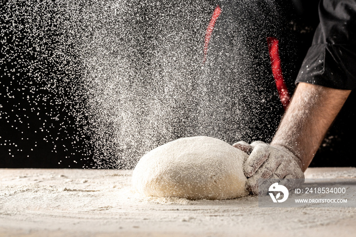 Male hands making dough for pizza. Beautiful and strong mens hands knead the dough make bread, past