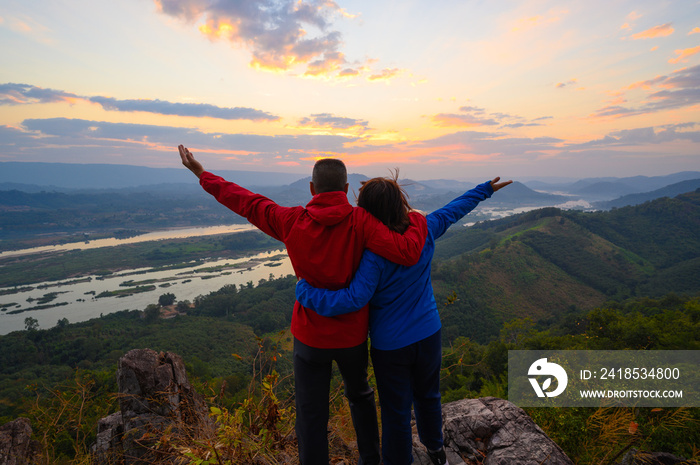 Senior healthy couple hiked the hill to see the sunrise view over Mekong river at Phu Pha Dak hill i