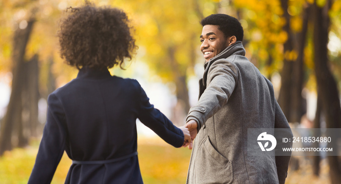 Follow me. Happy couple walking in autumn city park