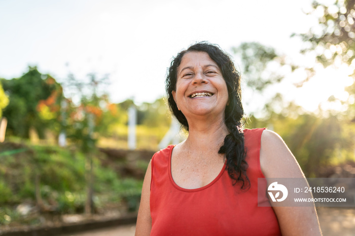 Portrait of smiling beautiful female farmer. Woman at farm in summer day. Gardening activity. Brazil