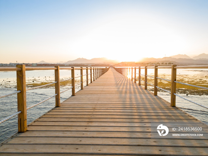 Beautiful photo of long wooden pier or bridge in the ocean