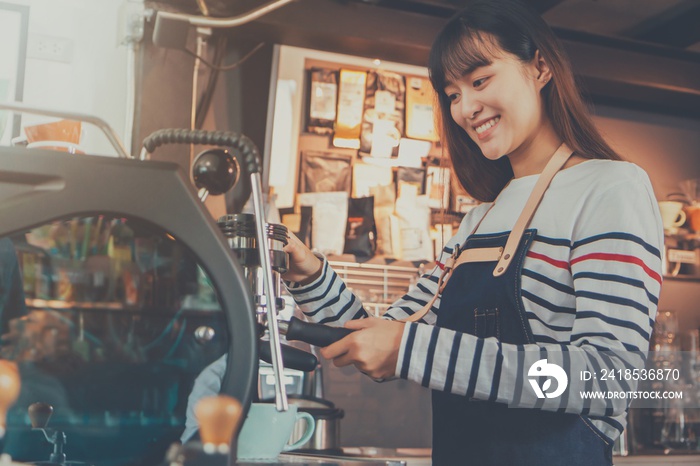 Young beautiful Asian woman barista wear blue apron holding hot coffee cup served to customer at bar