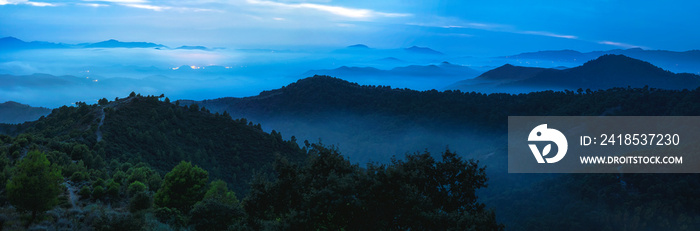 Image of a beautiful dark blue mountain landscape with fog and forest. Sunrise or sunset in the moun