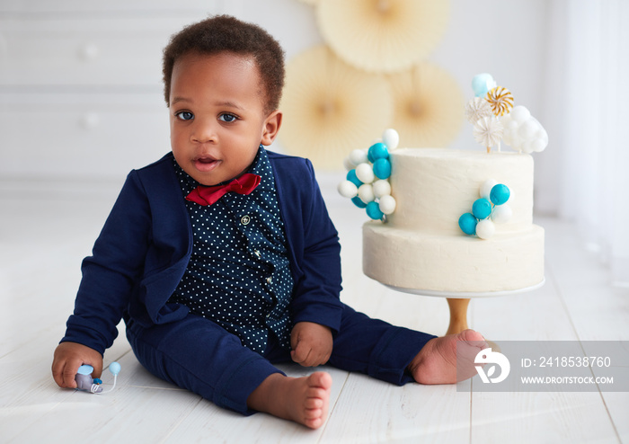 cute one year old baby boy with a birthday cake