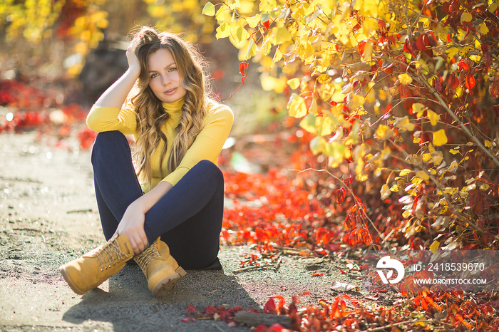 Young attractive blond woman outdoors on fall background. Autumn portrait of beautiful stylish woman