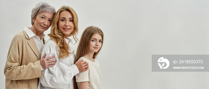 Side view of three females posing in white studio