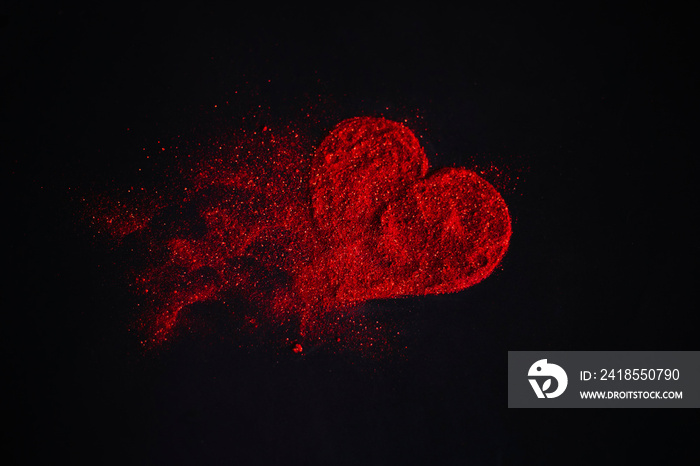 由黑色背景上的闪光组成的分散的红色心形。闪闪发光的灰尘符号。