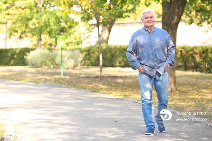 Handsome mature man walking in park