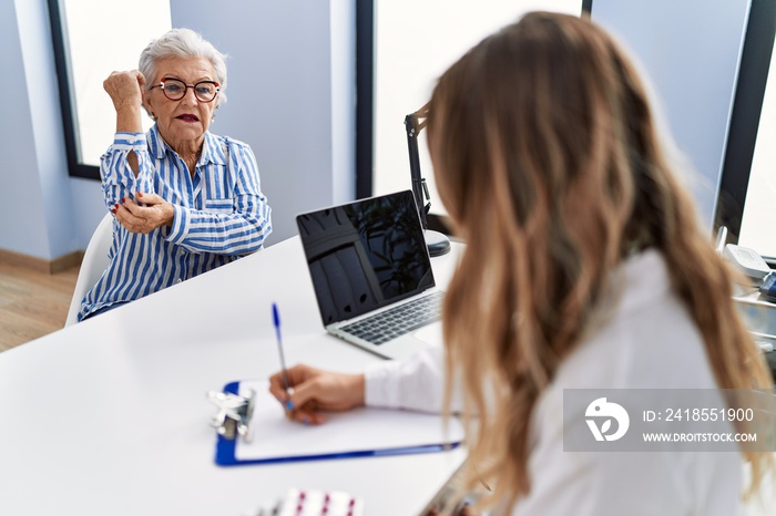 Senior grey-haired woman patient having medical consultation at clinic