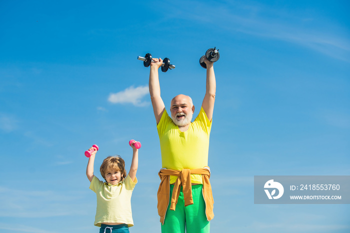 Active healthy life for family. Senior man and child exercising on blue sky. Grandfather and child i