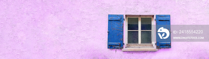 Fenster mit blauen alten und mit Spinnweben behangenen Fensterläden. Die Hausfassade ist rosarot.