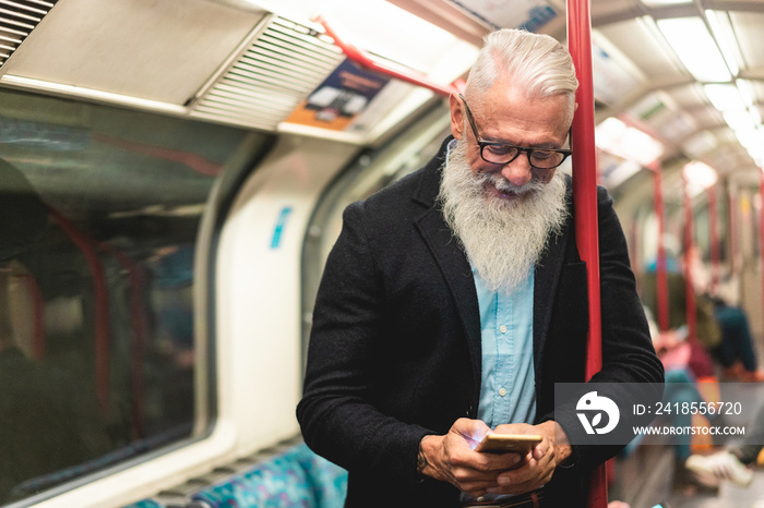 Senior hipster man using smartphone in subway underground train - Fashion mature person travels by t