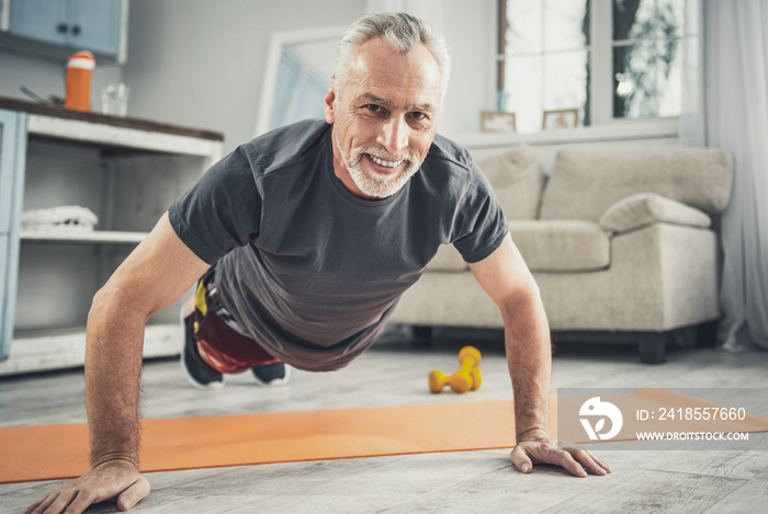 Contended athletic man doing push ups