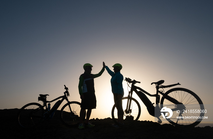 Elderly couple of caucasian old man and woman enjoying riding in a spring sunset in front to the sea