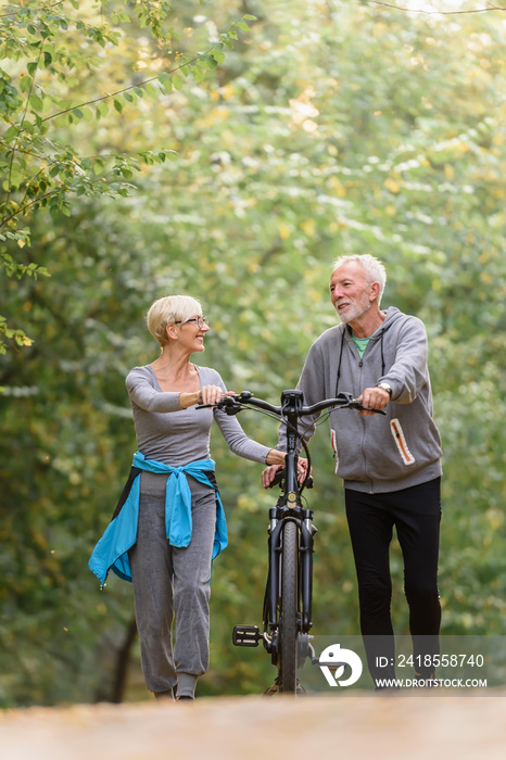 快乐活跃的老年夫妇骑着自行车一起穿过公园。这是el的完美活动
