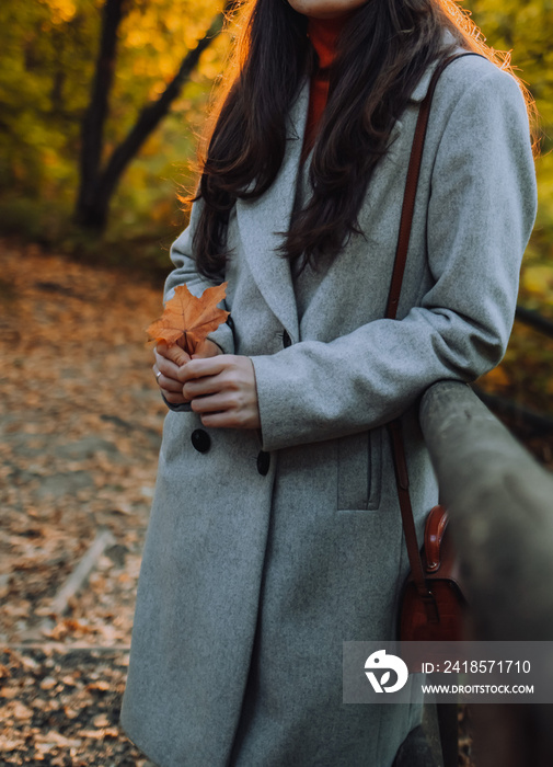 街上女人外套的特写。秋天枫叶女孩