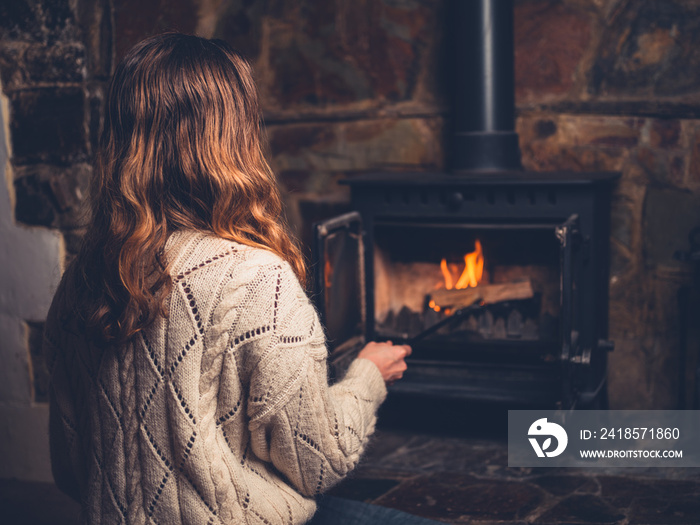 Young woman poking a fire