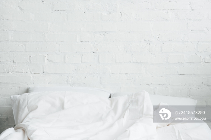 Empty and cozy bed with white pillows and blanket