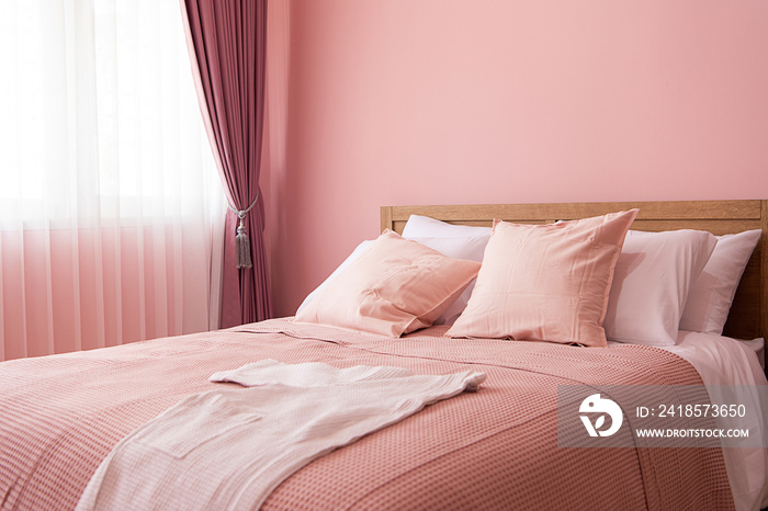 卧室室内，靠近粉色墙壁的舒适床，