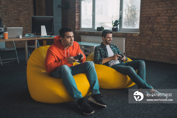 Joyful young men relaxing together at home