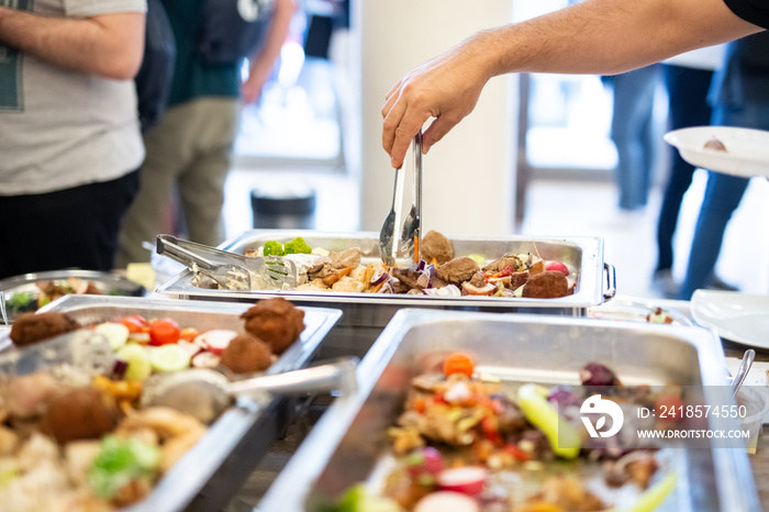 Self service catering buffet concept with hand scoping food.