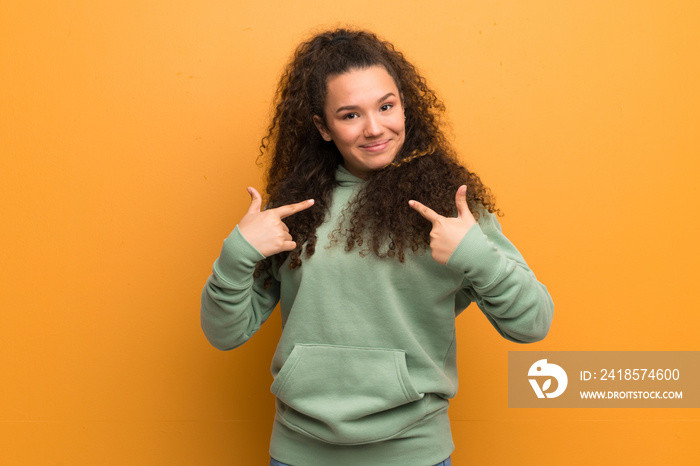 Teenager girl over ocher wall with surprise facial expression