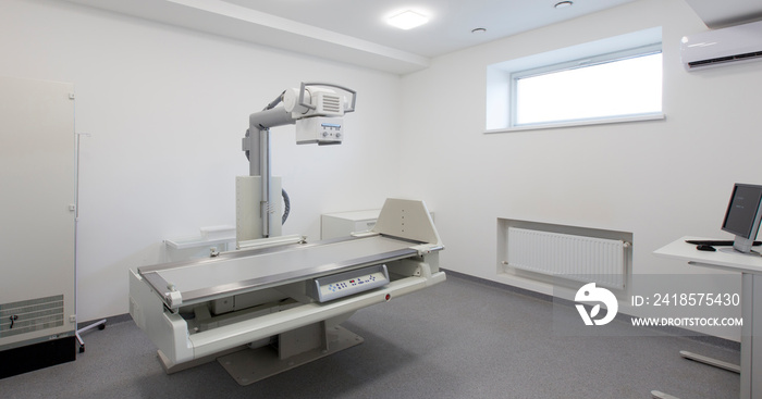 Modern X-ray machine in empty room in clinic