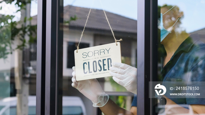 Sorry closed sign board hanging on glass door at the coffee shop.