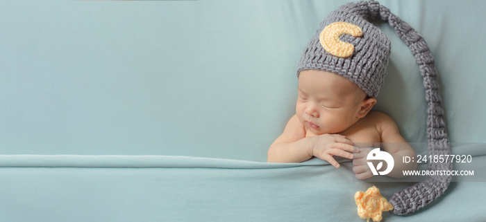 Adorable newborn baby sleeping in cozy room. Cute happy infant baby portrait with sleepy face in bed