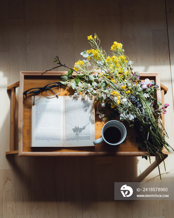 A book flat lay with flowers and coffee