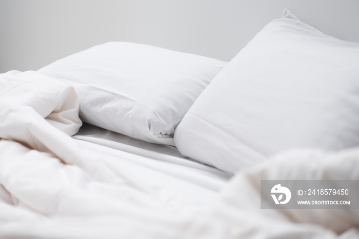 selective focus of empty bed with white pillows and blanket