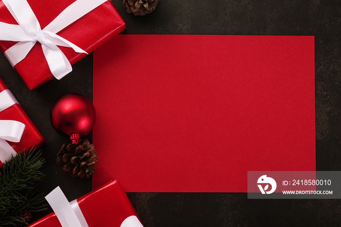 Blank red greeting card mockup with christmas gifts decorations on grunge background.