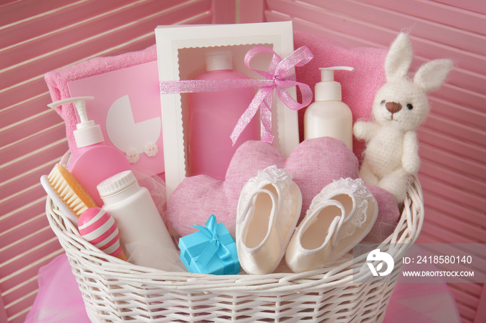 Wicker basket with baby shower gifts indoors