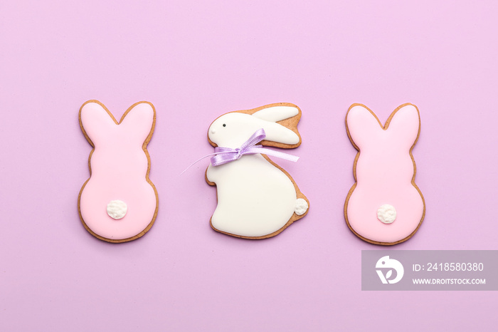 Delicious Easter cookies in shape of bunny on purple background